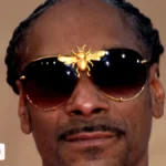 Snoop Dogg wearing sunglasses and a gold chain in 2019, featured in this Snoop Dogg net worth profile